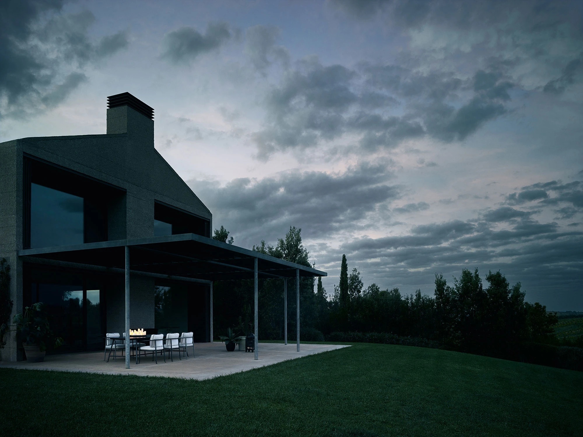 B&B Italia Borea outdoor dining under a villa pergola at dusk