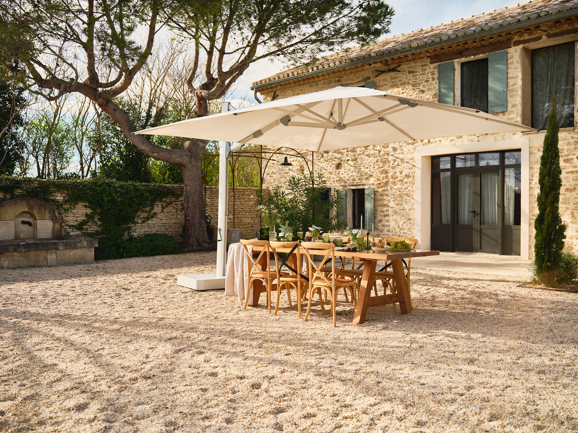 A Glatz Ambiente Nova cantilever parasol over a stone-terrace dining table at a Provençal property