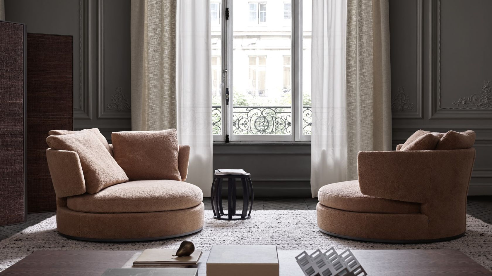 Two Maxalto Amoenus swivel chairs around a side table in a panelled Parisian interior, no people