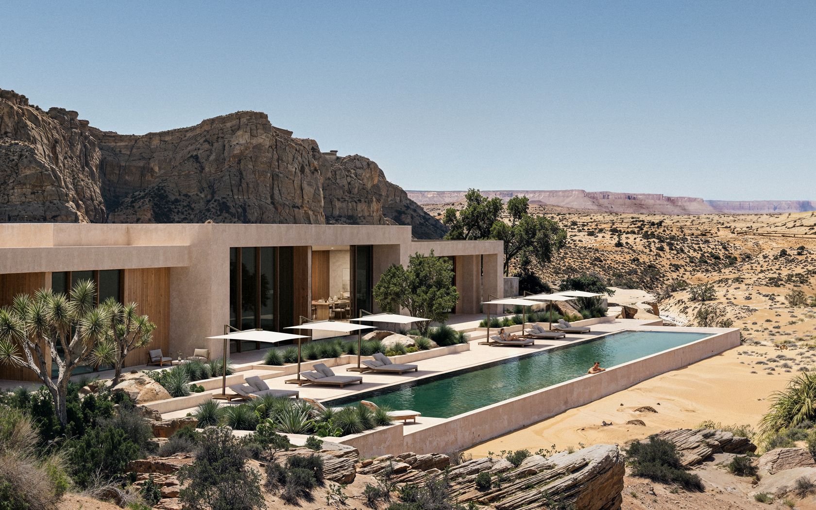 Umbrosa Aurelis parasols shading a poolside terrace at a desert resort, no people