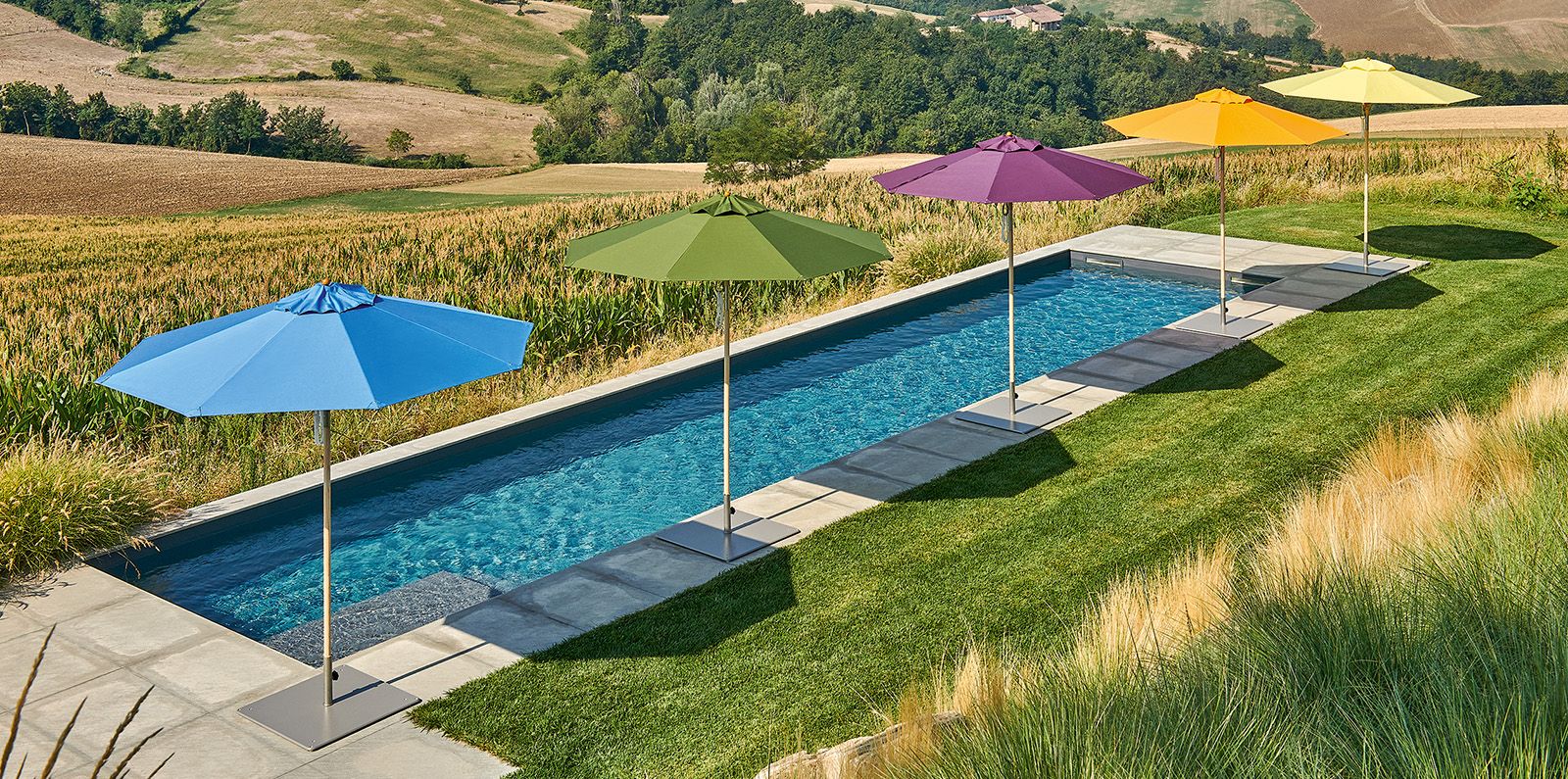 Weishäupl Klassiker parasols in multiple colours beside a hillside swimming pool, no people